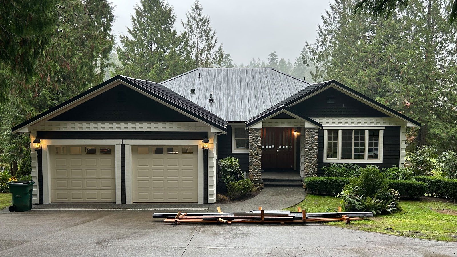 Finished standing-seam metal roof on a craftsman home in the trees