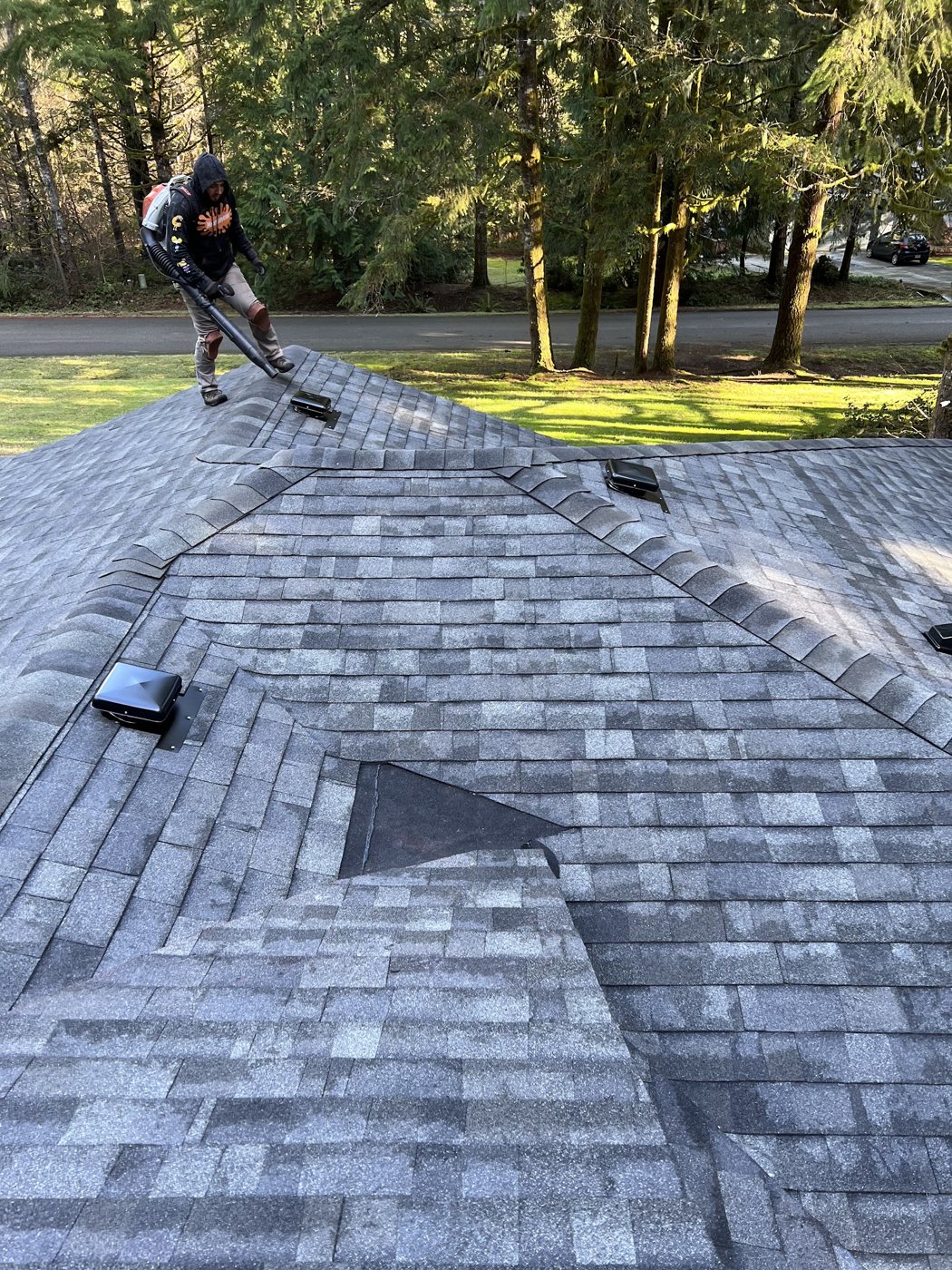 Crew member finishing a new architectural shingle roof
